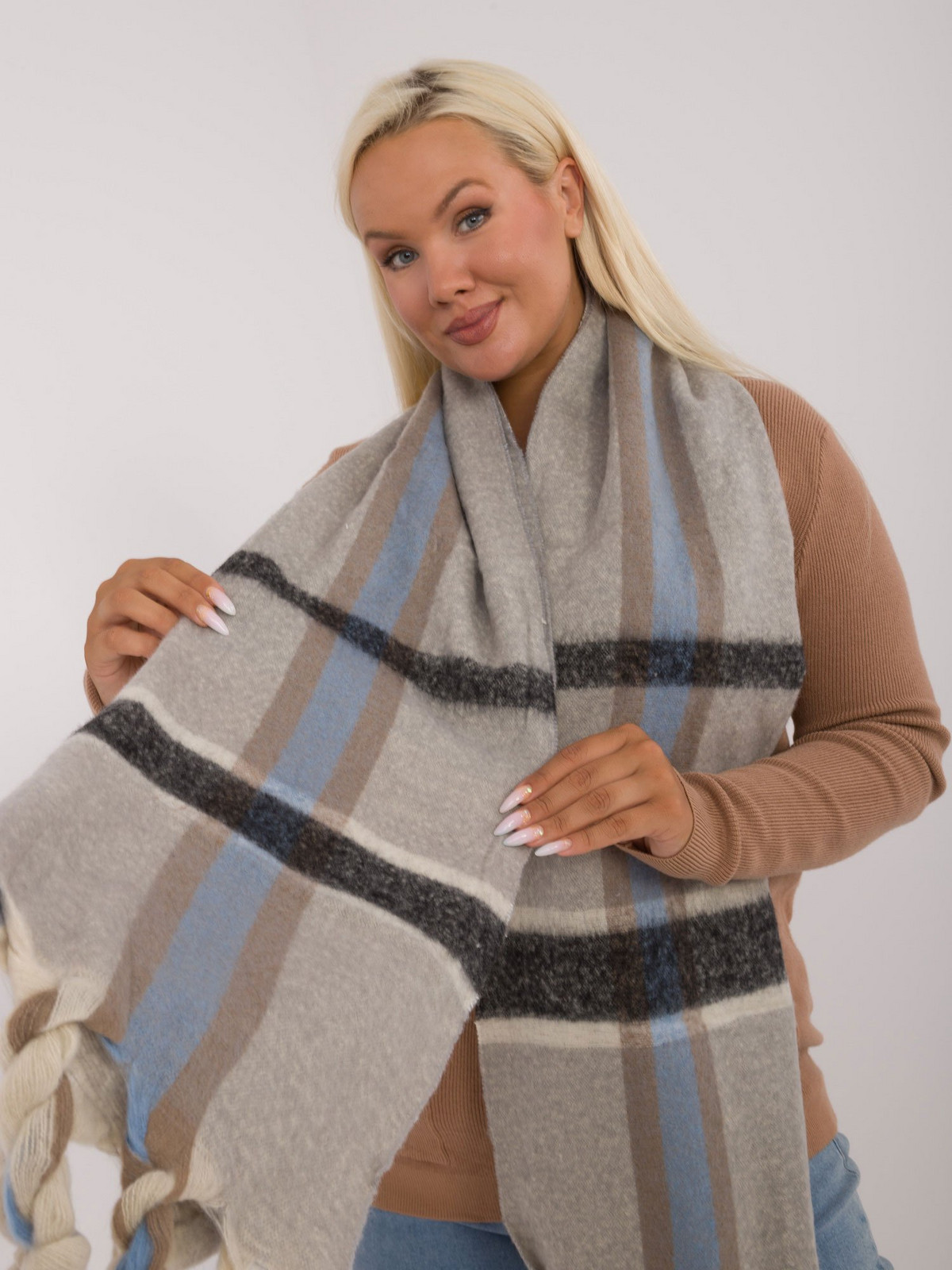 Grey warm women's scarf made of thick knitted fabric with fringe